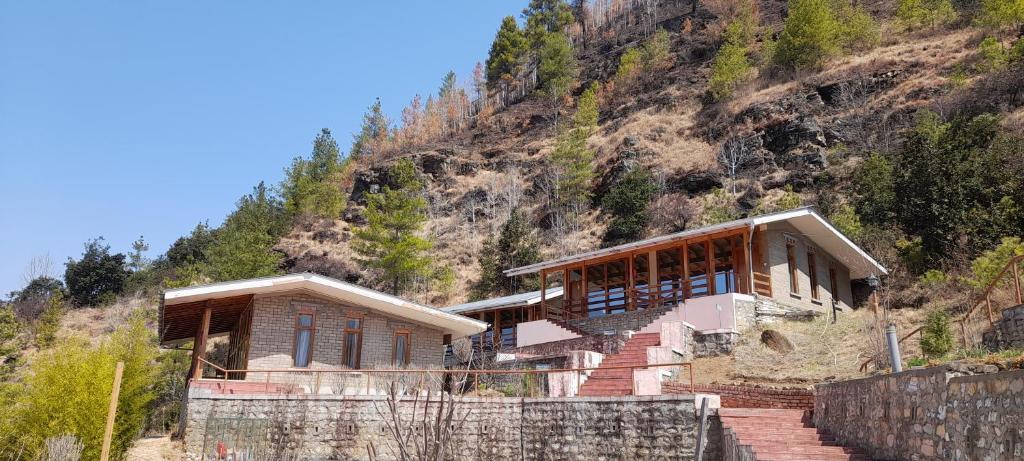 a house on the side of a mountain at Zhingkham Guest Houses in Thimphu