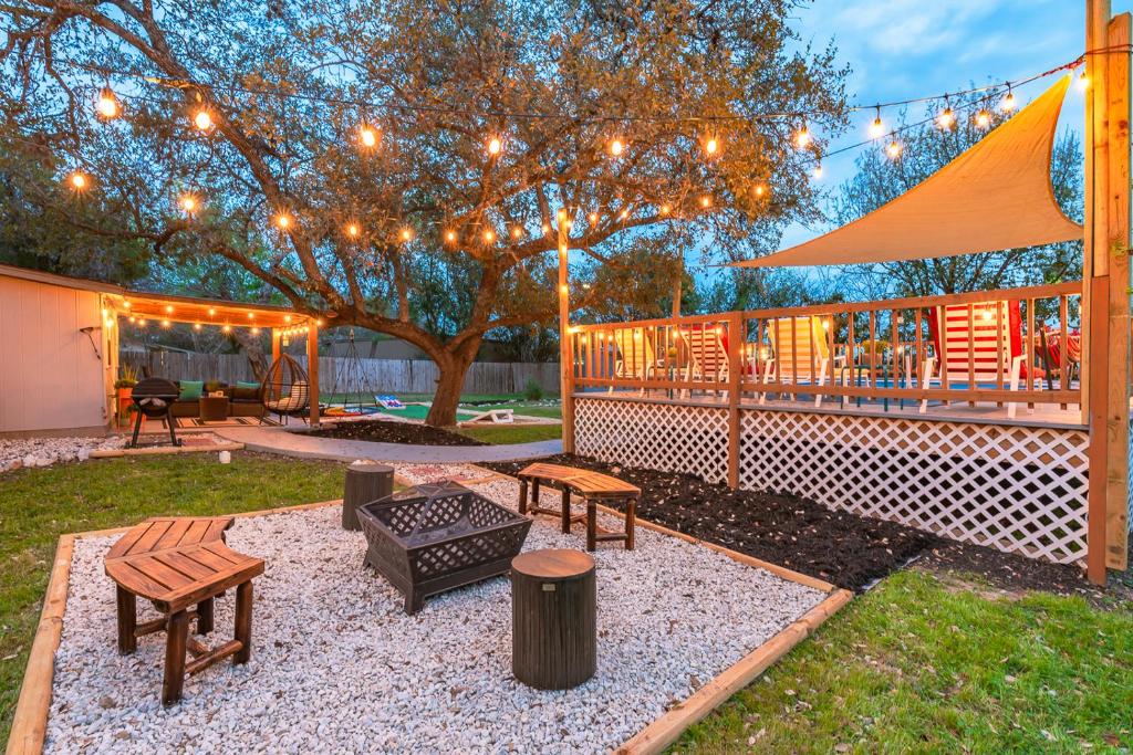 un patio trasero con una tienda, bancos y un árbol en Texas Vacation Home, Game Room & Pool By Sixflags, en San Antonio