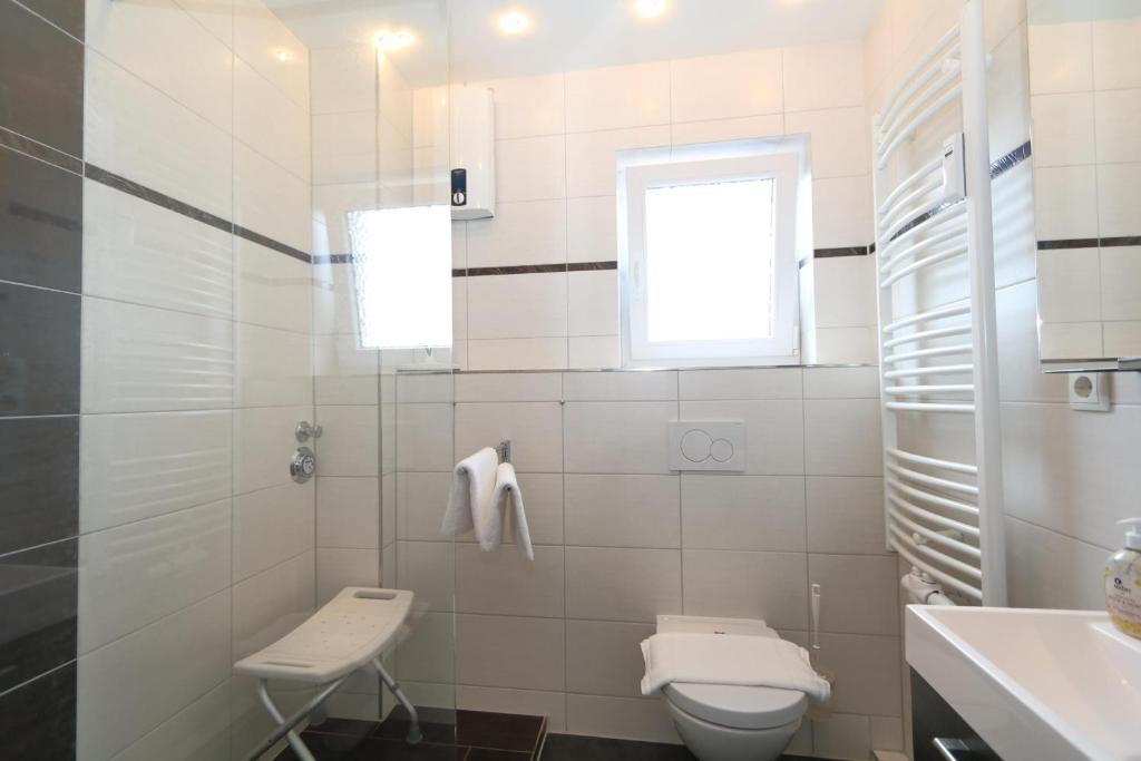 ヴェニングシュテットにあるPuschmann App. 26の白いバスルーム(トイレ、シンク付)