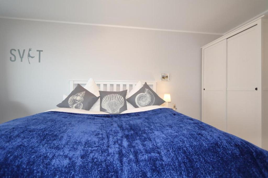 uma cama com um cobertor azul em cima em Haus am Meer14 - App 129WB em Westerland