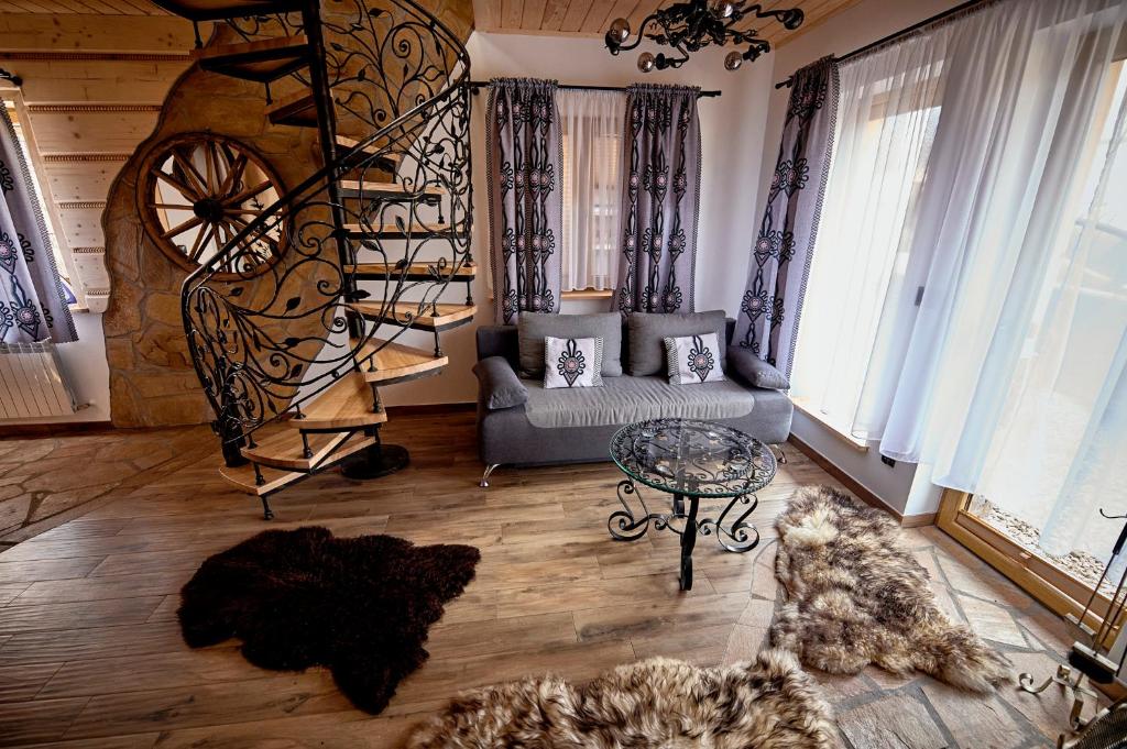 sala de estar con sofá y escalera de caracol en Domki Pod Góralskim Niebem, en Zakopane