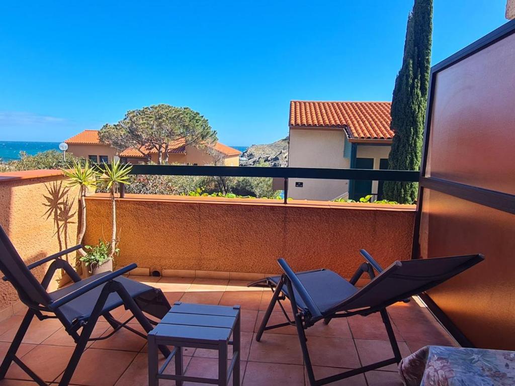 - un ensemble de chaises sur un balcon avec vue dans l'établissement Joli T2 avec balcon vue mer et parking à Collioure - FR-1-309-433, à Collioure