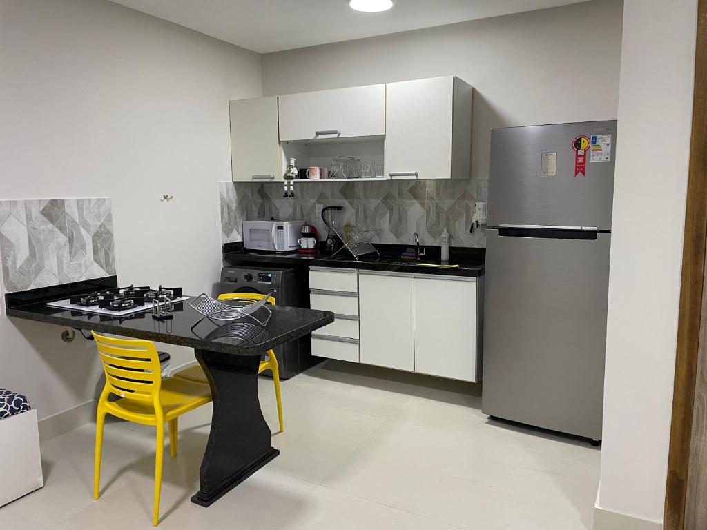 a kitchen with a black table and a refrigerator at 3 Conforto próximo ao Forum in Manaus