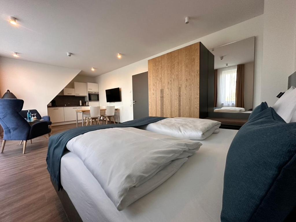 a large bedroom with two beds and a kitchen at Hotel Schöne Aussicht, Stilvoll modern, direkt am Rüstersieler Hafen in Wilhelmshaven