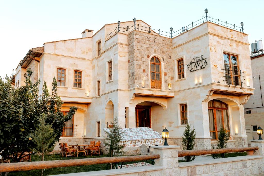 an old stone building with a table in front of it at Flavia Cappadocia Hotel in Uchisar