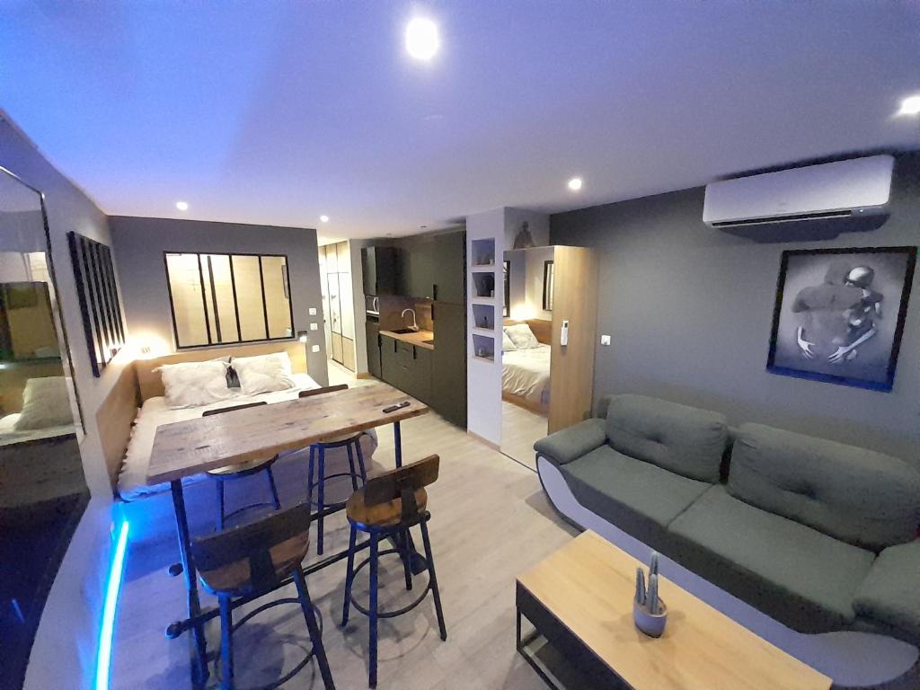 ein Wohnzimmer mit einem Sofa und einem Tisch in der Unterkunft Appartement Village Naturiste Sensuel in Cap d'Agde