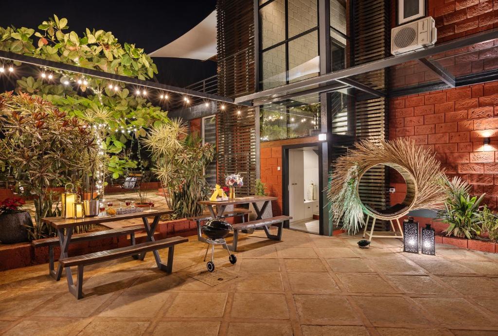 a lobby with benches and plants in a building at SaffronStays Calvin - 3 Bedroom Pool Villa In Lonavala in Lonavala