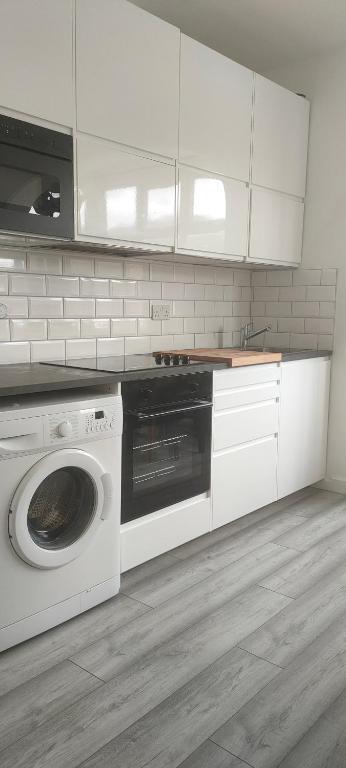 a kitchen with a washing machine and a sink at Serviced Accommodation in London in Croydon