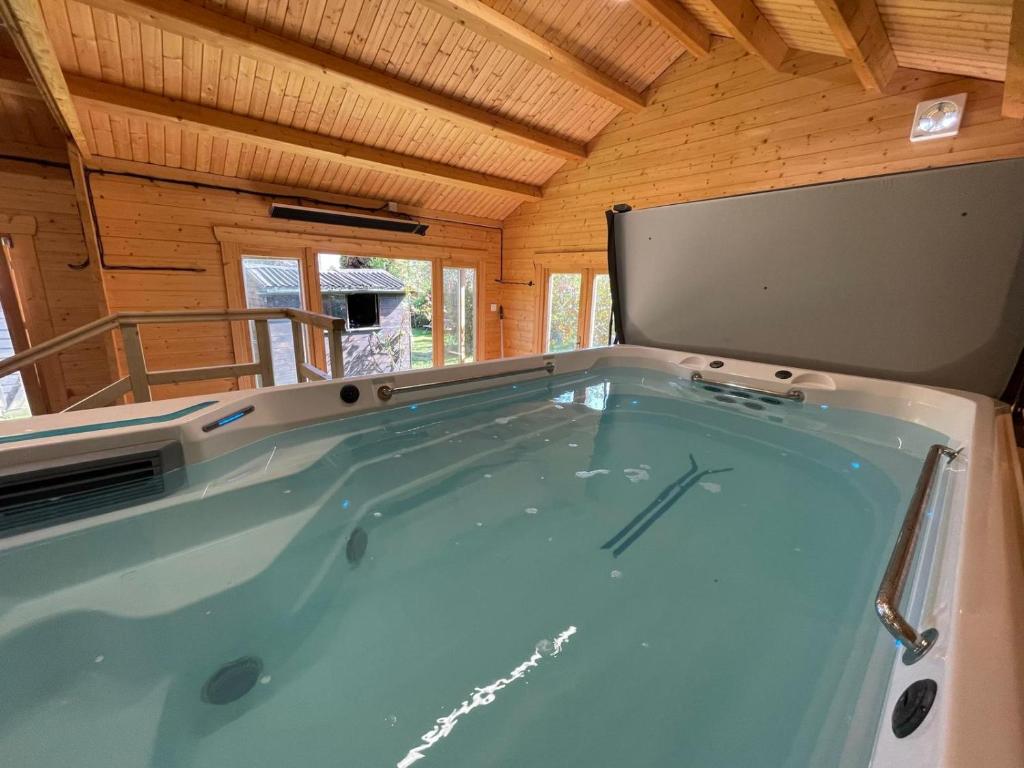 a jacuzzi tub in a cabin with a wooden ceiling at Entire Property & Luxury Pool, Wi-Fi & Parking in Southend-on-Sea