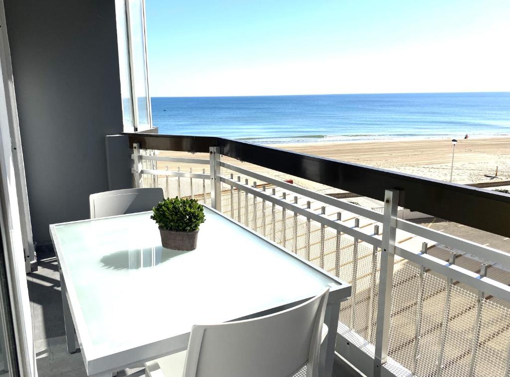 a white table and chairs on a balcony with the beach at Beachfront and Charming Apartment in Mareny Blau