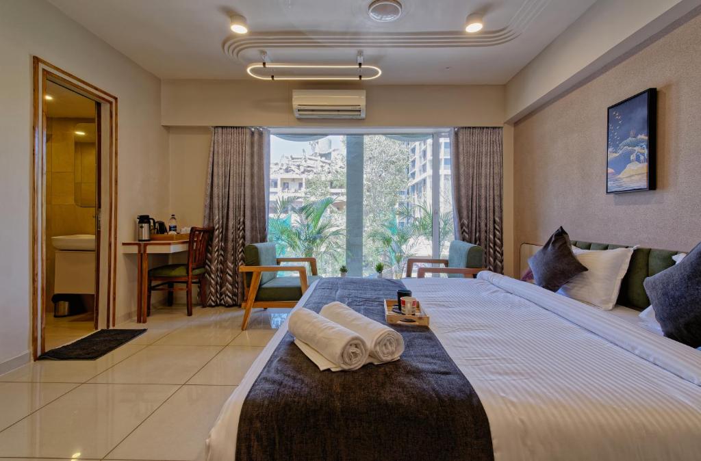 una habitación de hotel con una cama grande con toallas. en Exora Inn, en Ahmedabad
