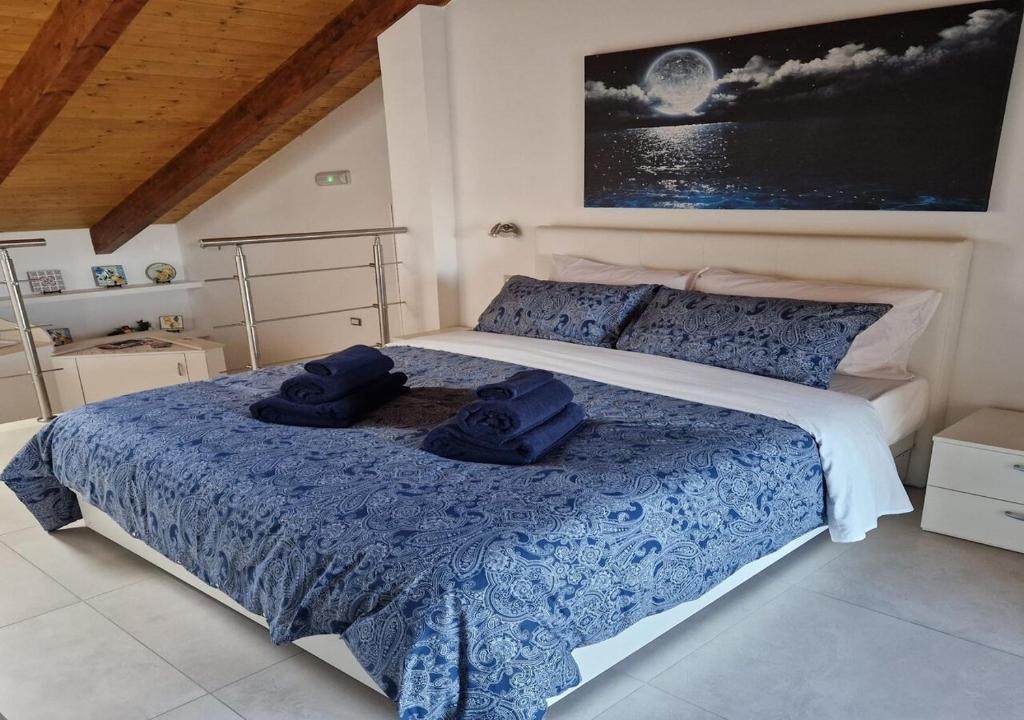 アジェーロラにあるCasa Vacanze Marelunaのベッドルーム1室(青と白のベッド、タオル付)