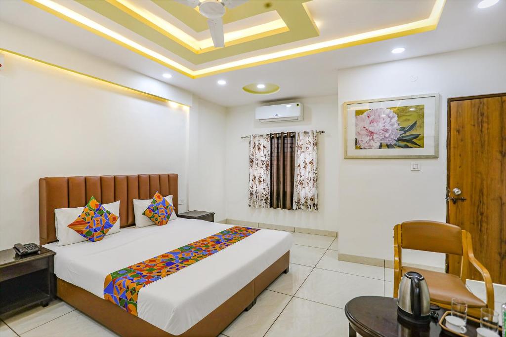 a bedroom with a bed and a desk and a chair at FabHotel Dhruva in Phanda