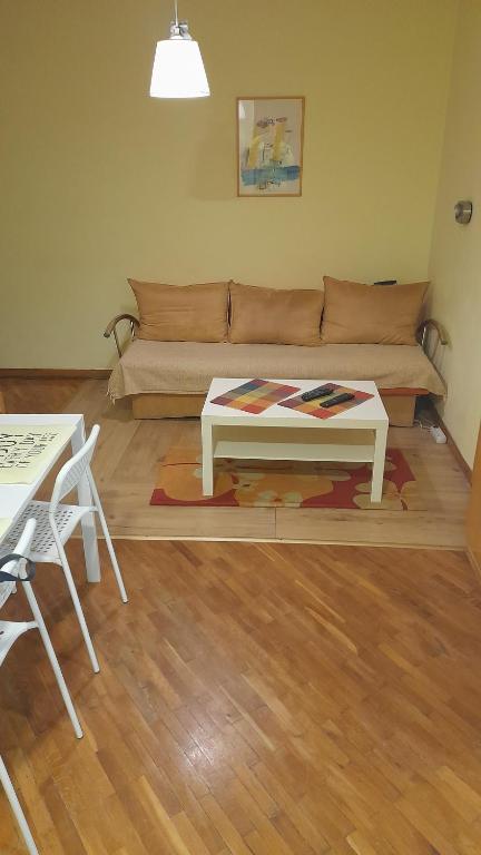 een woonkamer met een bank en een tafel bij Vracar Krunska Jamiva in Belgrado