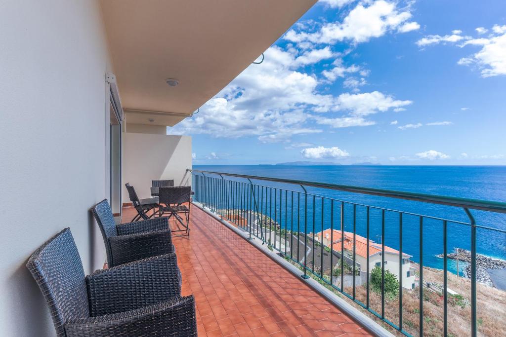 a balcony with chairs and a view of the ocean at Sunspot Reis Magos with sea view in Caniço