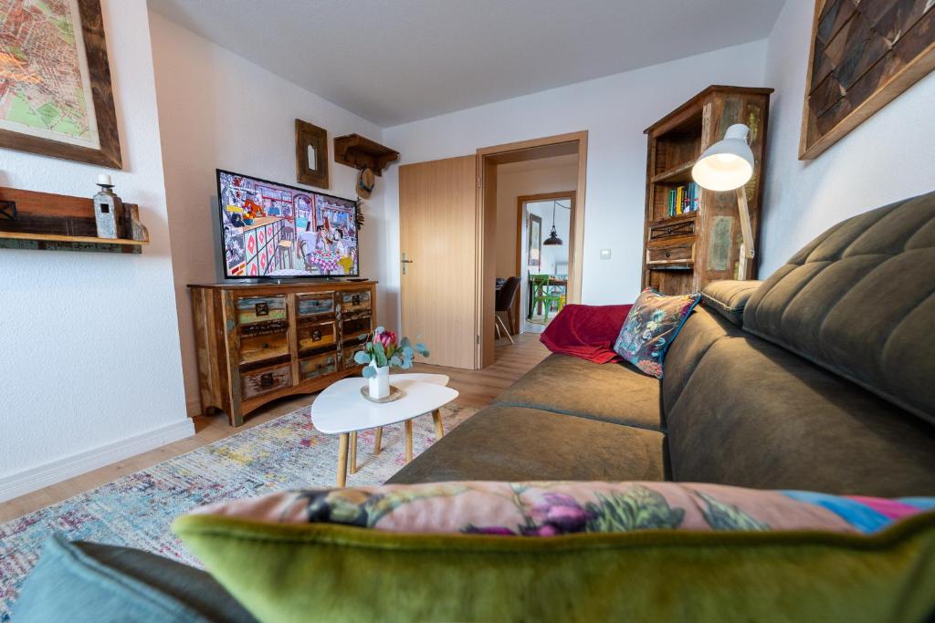 ein Wohnzimmer mit einem Sofa und einem TV in der Unterkunft Schloßberg-Domizil mit Weitblick - Arbeitsplatz, Balkon, Netflix, Badewanne & Yogamatte in Chemnitz