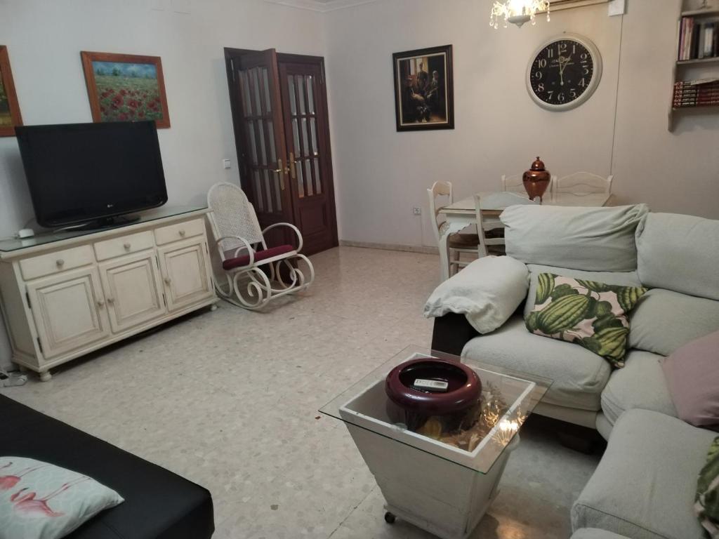 a living room with a couch and a tv at Casa Tagore in Utrera