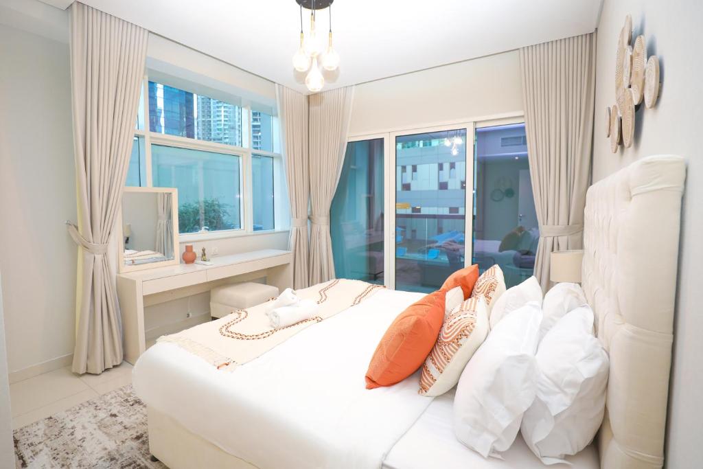 a bedroom with a white bed with pillows and a window at Business Bay 1BR Gem Luxe Living in Dubai