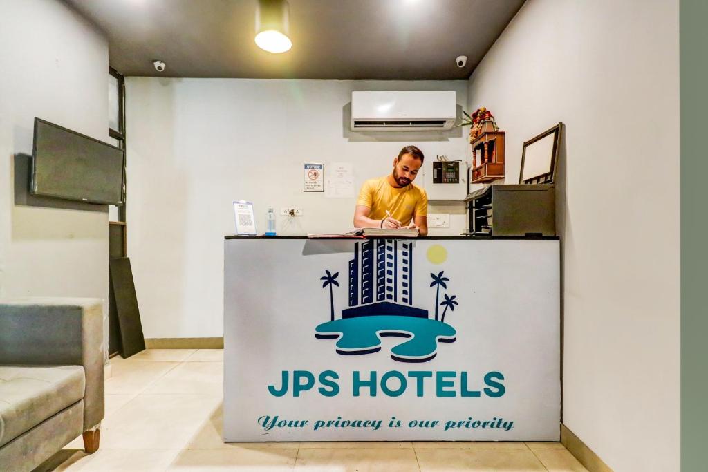 Un uomo in piedi al bancone in una cucina di OYO Flagship JPS Grand Hotel a Nuova Delhi