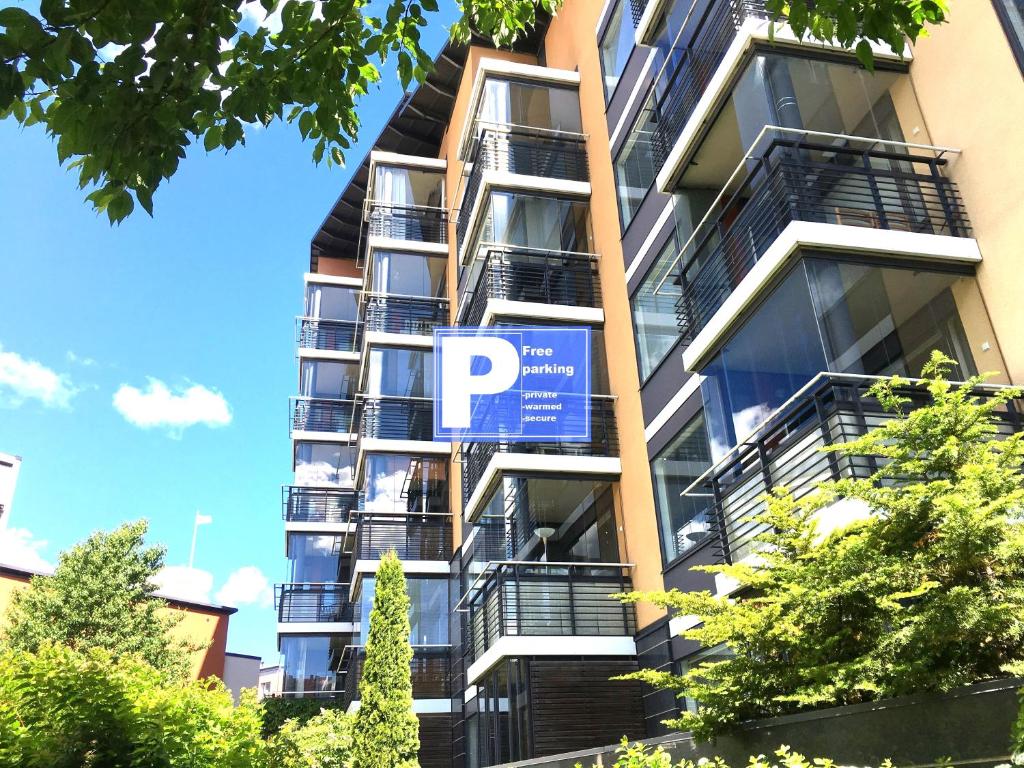 ヘルシンキにあるTop Apartments Helsinki - Tilkkaの駐車場の標識が付いたアパートメントビル