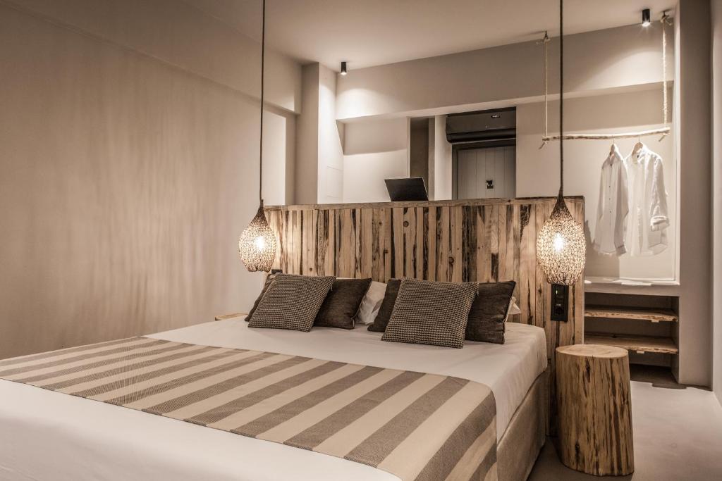 um quarto com uma cama com duas luzes em Doryssa Boutique Hotel em Pythagoreio
