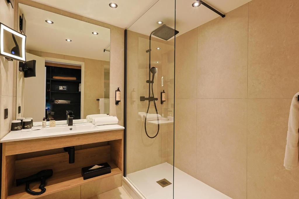 a bathroom with a sink and a shower at Golf Hôtel de Valescure &amp; Spa NUXE in Saint-Raphaël