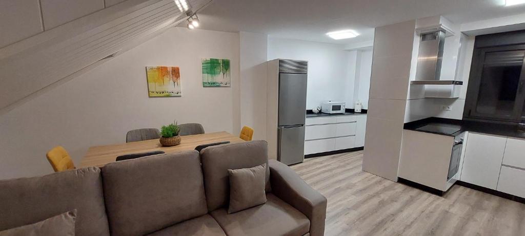 a living room with a couch and a table in a kitchen at APARTAMENTO Temple I in Ponferrada