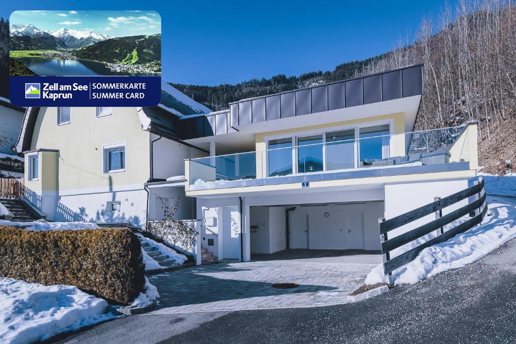 a house in the snow with a driveway at Panorama Chalet Schmittendrin by we rent, SUMMERCARD INCLUDED in Zell am See