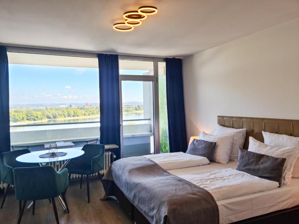 um quarto com uma cama, uma mesa e uma janela em Rheinblick Apartments em Colônia