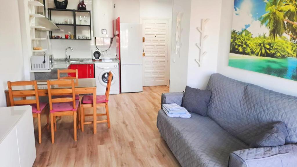 een woonkamer met een bank en een tafel en een keuken bij BENALBEACH RESORT NEW APARTMENT - Benalmádena Málaga in Benalmádena