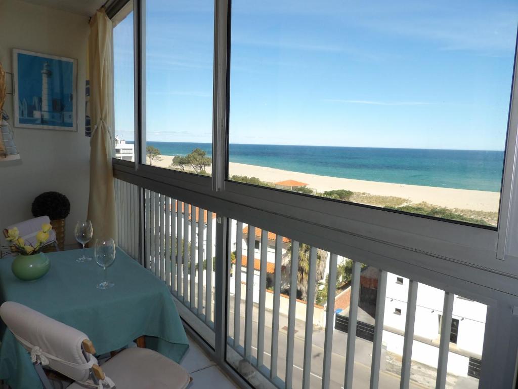 een balkon met een tafel en uitzicht op het strand bij Vue superbe sur la Belle Bleue avec 2 chambres in Saint-Cyprien