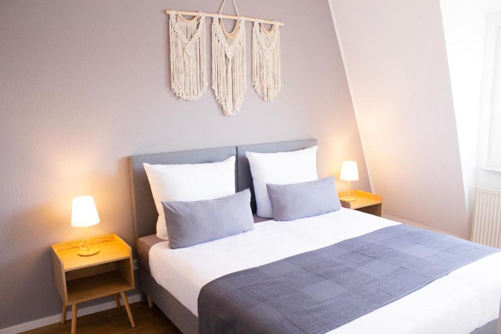 een slaapkamer met een groot bed met 2 lampen bij NOVA See APT 18 I Phantasialand, Cologne, Bonn in Erftstadt