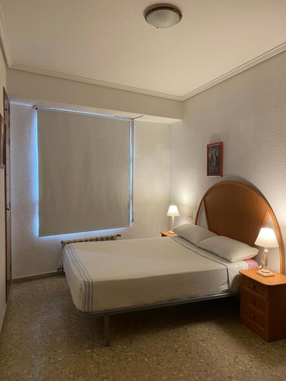 a bedroom with a bed and a large window at Casa del port in Grao de Castellón