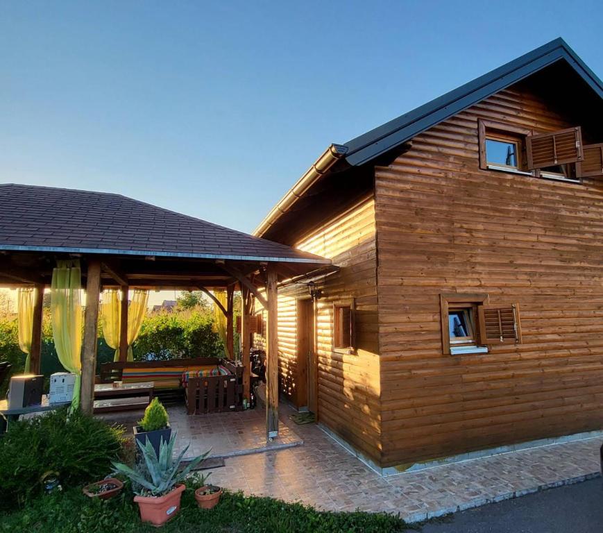 a wooden house with a patio in front of it at DRiM Wood House - no party house in Lasinja