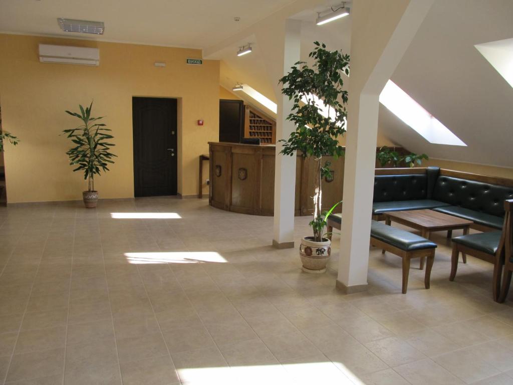 a lobby with a couch and tables and plants at Mini-hotel Na Pidgradskiy in Uzhhorod