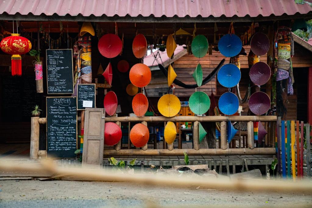 een winkel met kleurrijke paraplu's voor de deur bij Samaki Guesthouse - Tad Lo in Ban Donkhagnoung