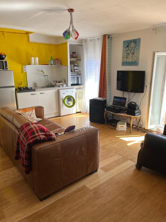 a living room with a couch and a kitchen at Tita in Manosque