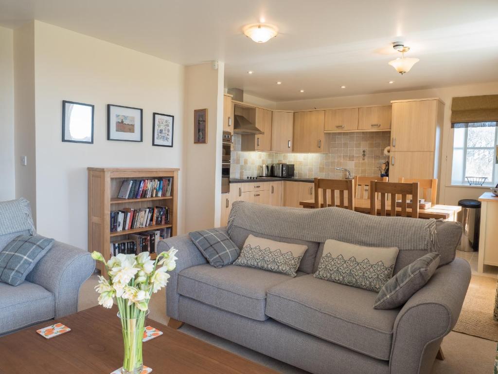 a living room with a couch and a kitchen at St Brides View Solva in Solva