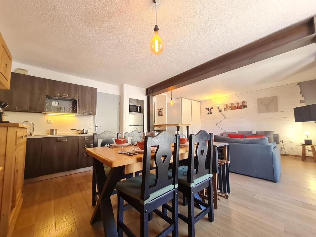 eine Küche und ein Wohnzimmer mit einem Tisch und Stühlen in der Unterkunft Andromede - 90 - Appart renove 6 pers in Les Deux Alpes
