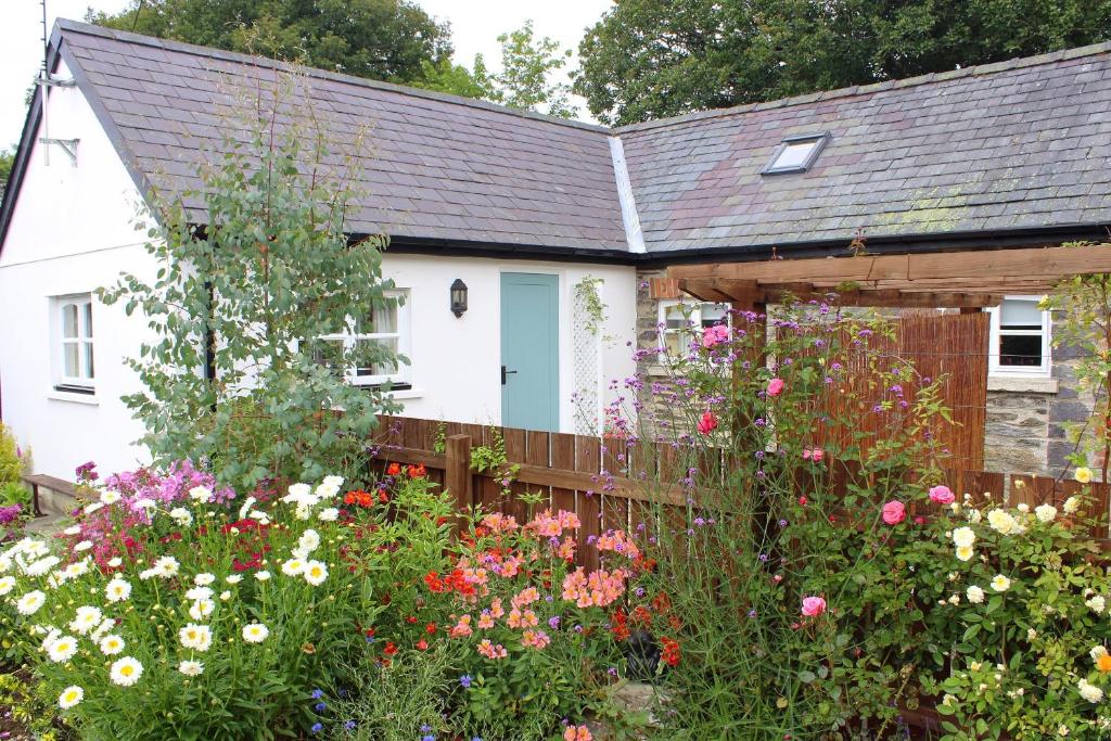 a garden in front of a house with flowers at The Hideaway Brongest in Troedyraur