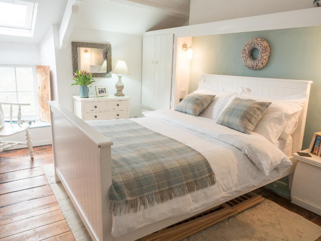 a bedroom with a large white bed in a room at Driftwood Cottage Llangrannog in Llangranog