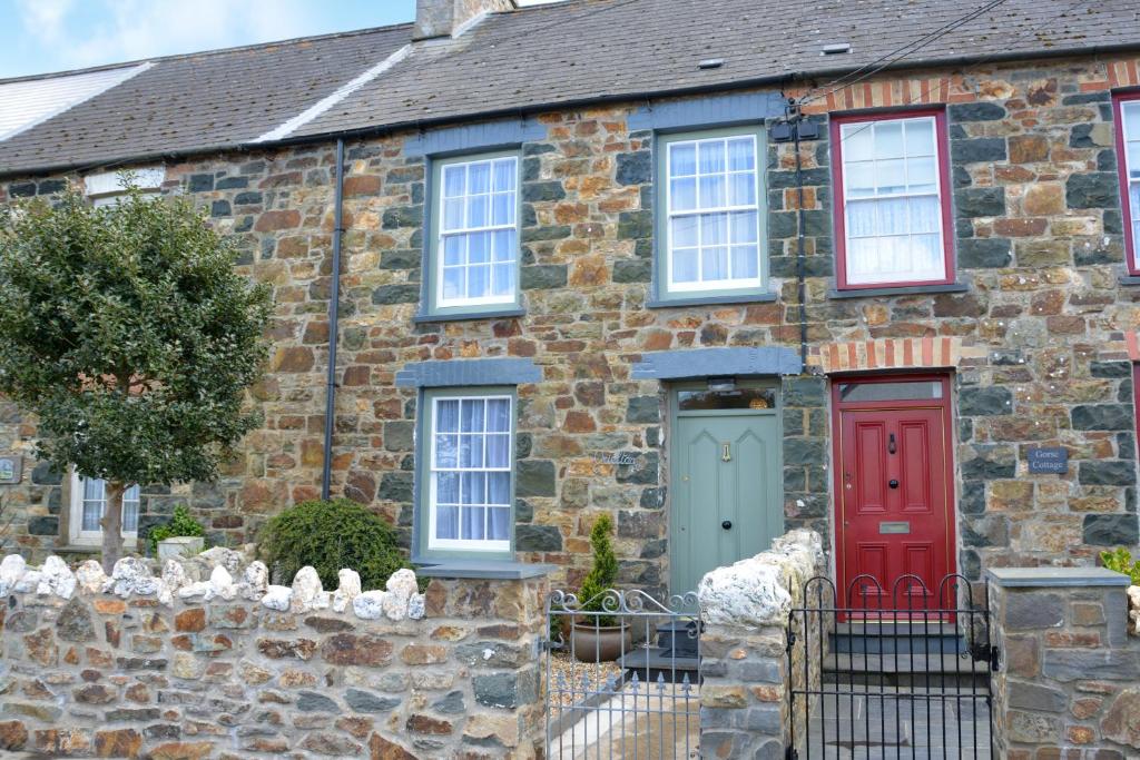 a brick house with red and green doors at Orielton Newport in Dinas