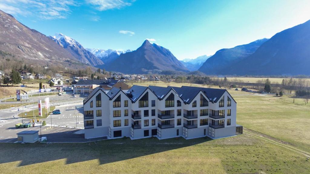 an aerial view of a building with mountains in the background at Soca Valley Suites in Bovec