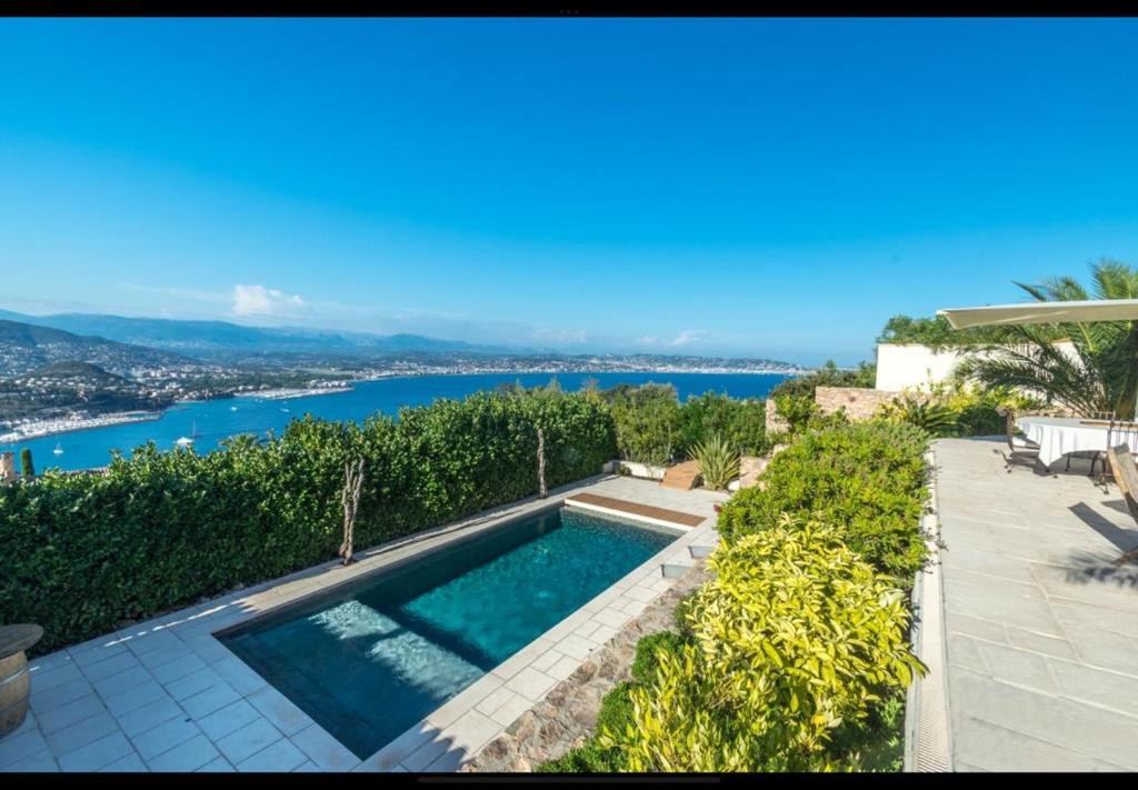 a swimming pool with a view of the water at Maison de charme vue mer 5chambres Théoule sur mer in Théoule-sur-Mer