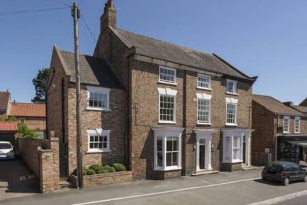a brick house with a car parked in front of it at Stylish Georgian Townhouse, Yorkshire - sleeps 12 in Easingwold