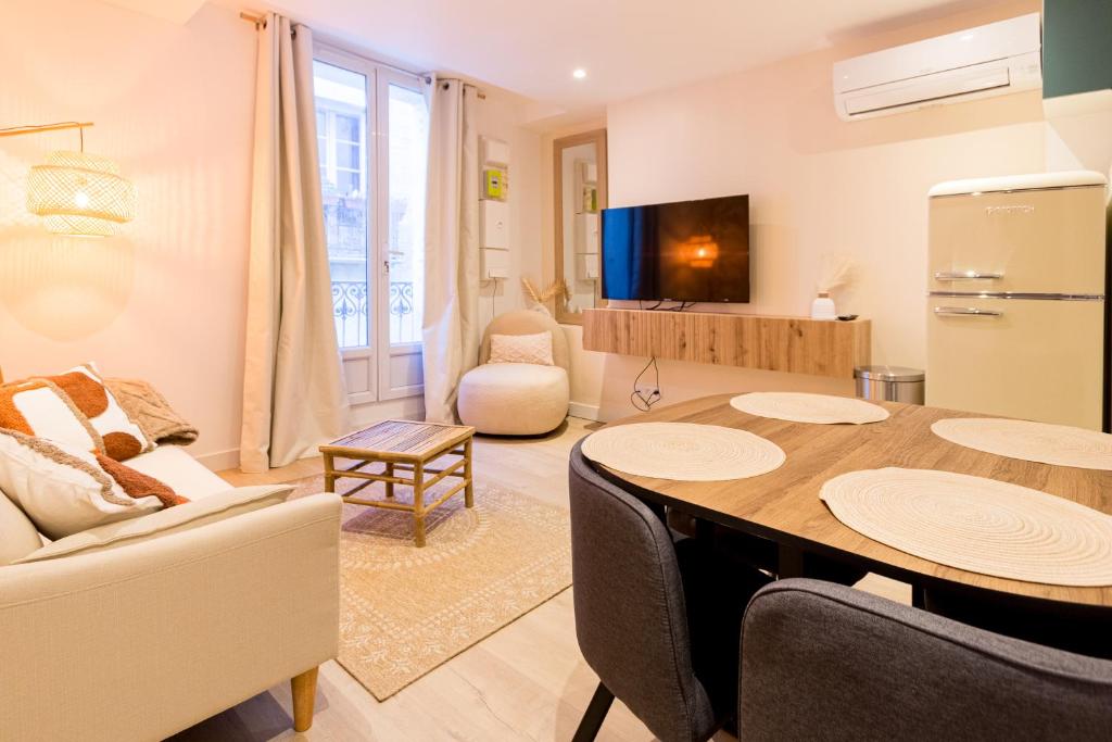 une cuisine et un salon avec une table et des chaises dans l'établissement Charmant T3 Neuf - Centre ville Décoration moderne, à Montpellier