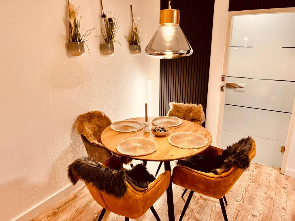 Stylish Apartment with Beautiful Ambiance في كولونيا: طاولة طعام مع كراسي و قلادة خفيفة