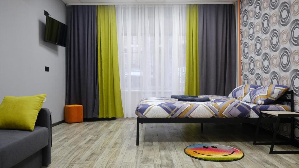 a bedroom with a bed and a couch at Uneed Rooms M1 in Kyiv