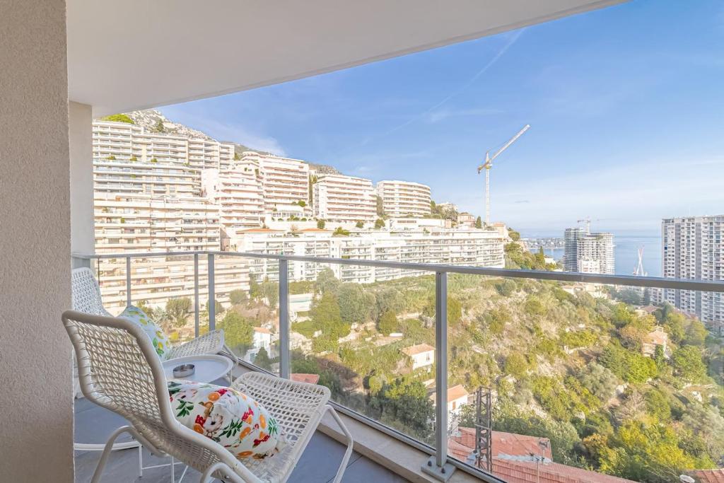 balcón con 2 sillas y vistas a la ciudad en Superb New 2-room Apartment -parking Beausoleil, en Beausoleil