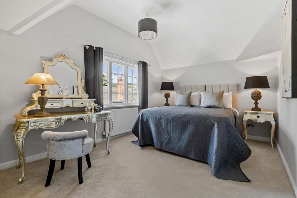 - une chambre avec un lit, un bureau et un miroir dans l'établissement Rosemary Cottage, à Leicester